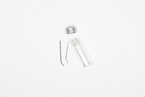 Tapestry needles in a glass vial